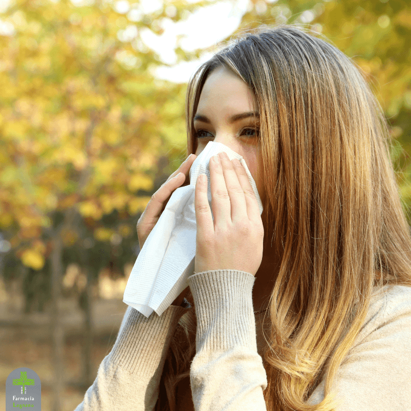 Donna all’aperto che si soffia il naso con un fazzoletto a causa delle allergie di fine estate.